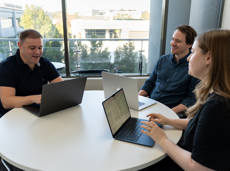 Earned Media team collaborating around laptops in the Sydney studio