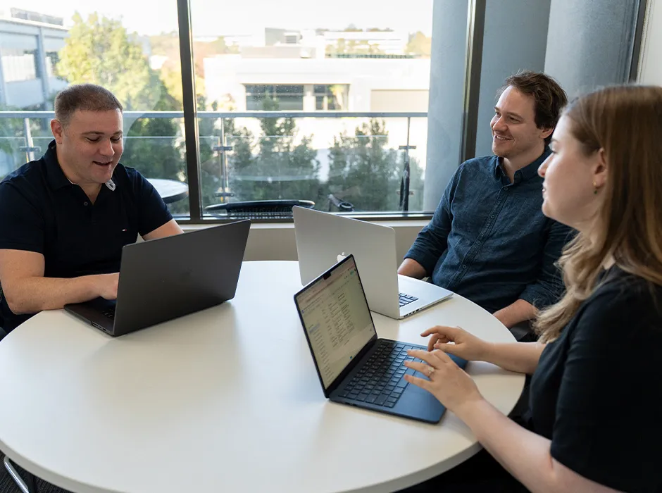 Earned Media team collaborating around laptops in the Sydney studio